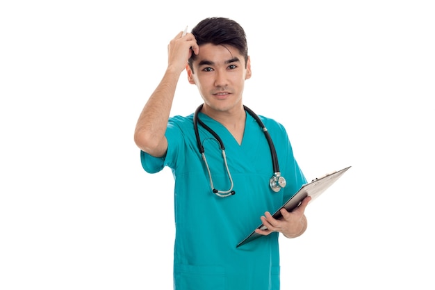 Retrato de estúdio de um médico muito masculino em uniforme posando isolado na parede branca