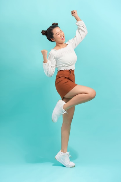 Retrato de estúdio de uma garota surpresa e positiva dançando