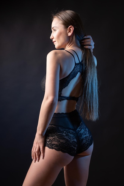 Retrato de estúdio de uma jovem esbelta em lingerie contra um fundo preto
