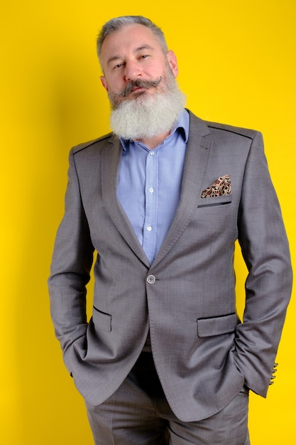 Retrato de estúdio maduro barbudo homem bonito em terno cinza