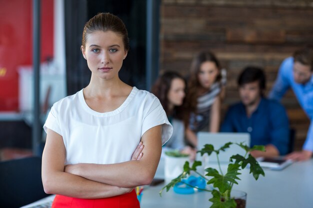 Retrato de executivo empresarial feminino em pé com os braços cruzados