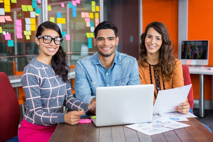 Foto retrato de executivos felizes sentados com um laptop e documentos