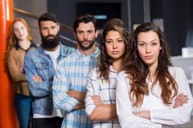 Retrato de executivos masculinos e femininos em pé com os braços cruzados