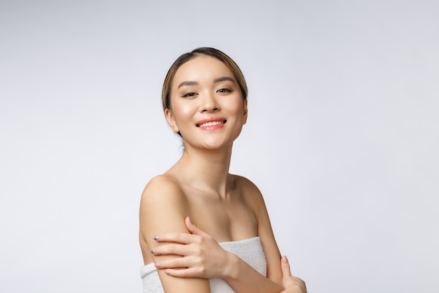 Retrato de face da asiática linda garota sorridente com cabelo curto, mostrando sua pele saudável