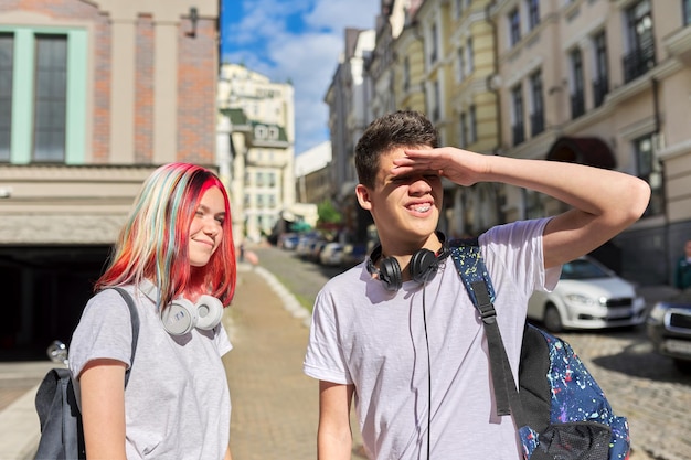 Retrato de falar de adolescentes adolescentes menino e menina 16, 17 anos na cidade olhando para a distância. Ensino médio e faculdade, comunicação, amizade, conceito de juventude