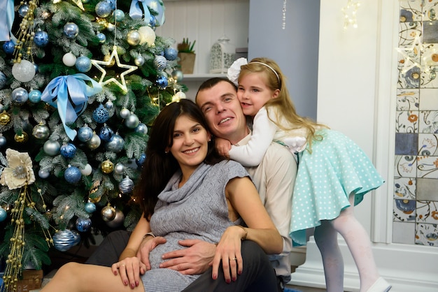 Retrato de família amigável, olhando para a câmera na noite de Natal.