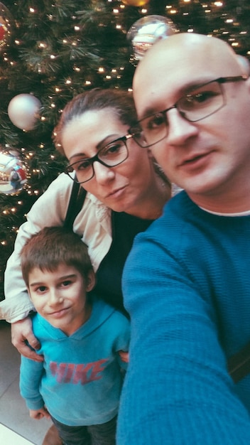 Foto retrato de família contra a árvore de natal à noite