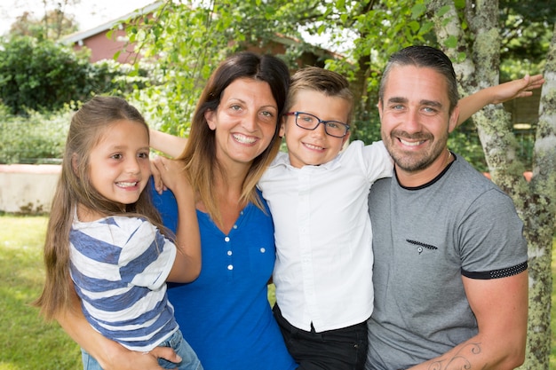 Retrato de família de quatro pessoas feliz sentado no parque de jardim em casa