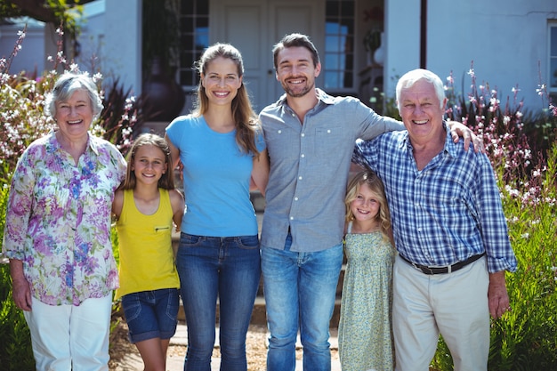 Retrato de família de várias gerações feliz contra casa