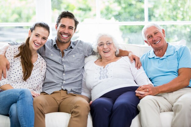 Foto retrato de família de várias gerações, sentado no sofá a sorrir