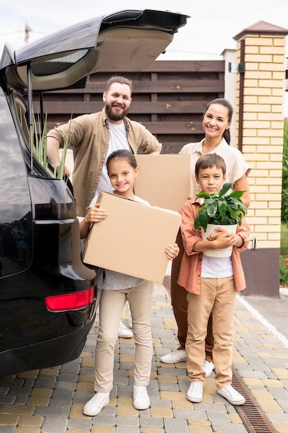 Retrato de família descarregando o porta-malas do carro