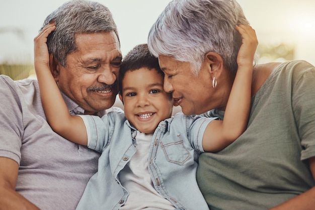 Retrato de família e criança com avós em um abraço de sala de estar e amor feliz e doce enquanto se unem em sua casa Abrace neto e avó com avô em um abraço de salão