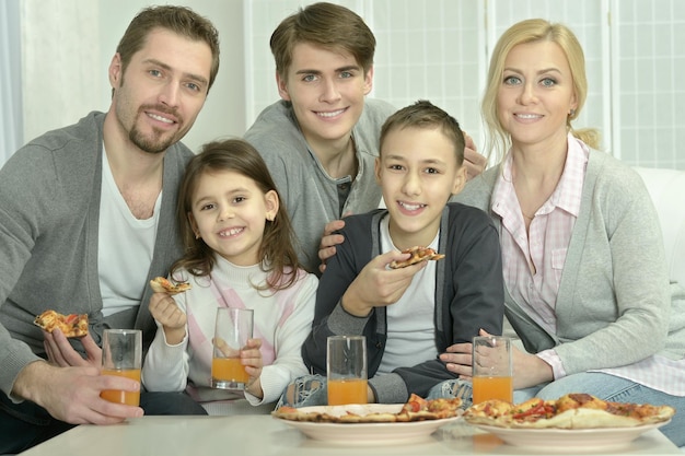 Retrato de família em casa com pizza