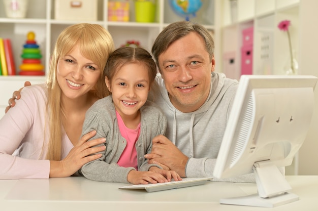 Retrato de família feliz com computador em casa