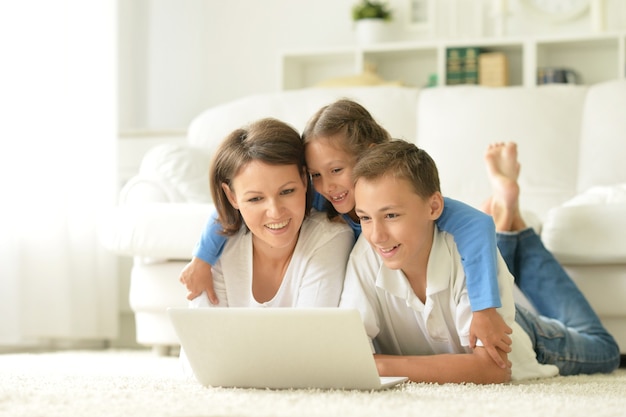 Retrato de família feliz com laptop em casa