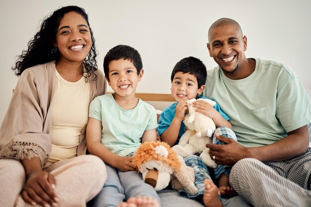 Foto retrato de família feliz de mãe pai e filhos com brinquedos de ursinho de pelúcia e vínculo doméstico brincando e aproveitando o tempo juntos felicidade manhã amor e sorriso mãe pai e filhos relaxam no quarto