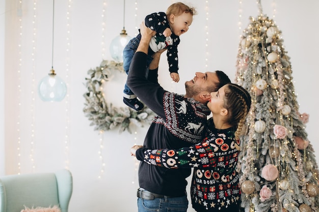 Retrato de família feliz de pai mãe e filho encaracolado celebrando o natal juntos em casa conceito de véspera de ano novo