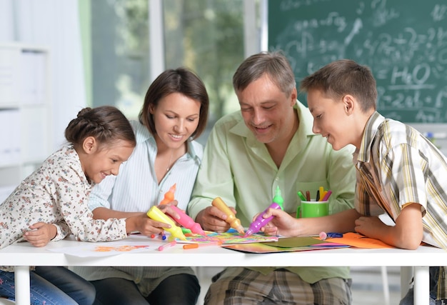 Retrato de família feliz de quatro desenhando juntos em casa