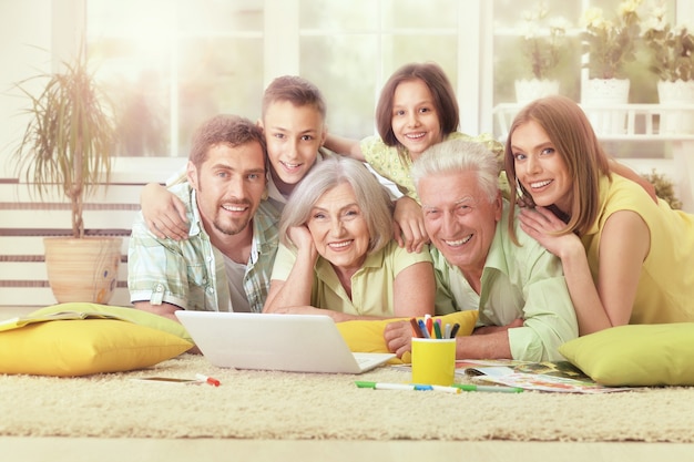 Retrato de família feliz em casa com laptop