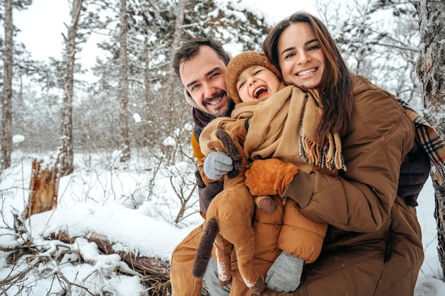 Retrato de família feliz em roupas de inverno na floresta