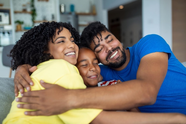 Foto retrato de família feliz pais sorridentes e sua filha bonitinha abraçando e posando juntos