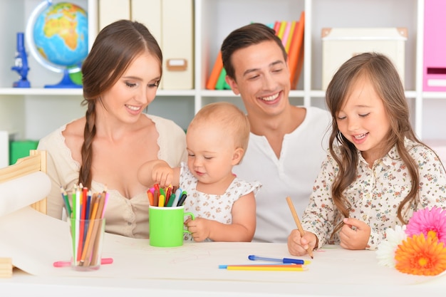 Retrato de família feliz pintando em casa