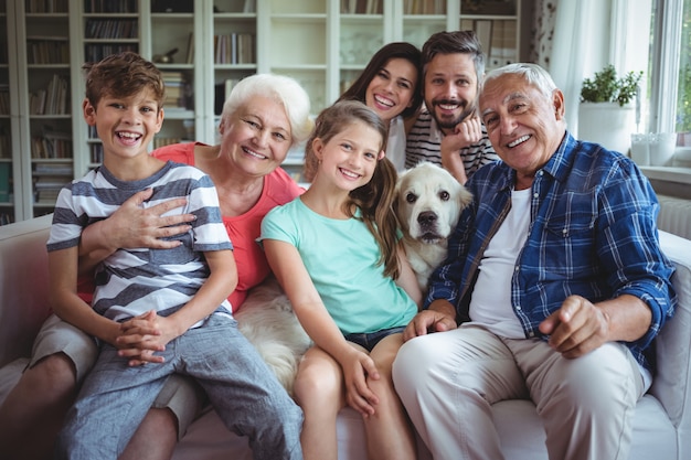 Retrato de família feliz sentado no sofá na sala de estar