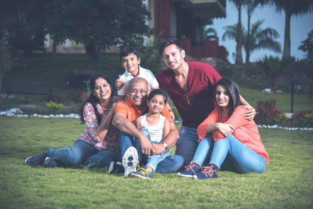 Retrato de família indiana asiática feliz sentado no gramado, ao ar livre