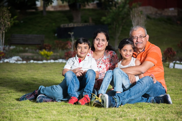 Retrato de família indiana asiática feliz sentado no gramado, ao ar livre