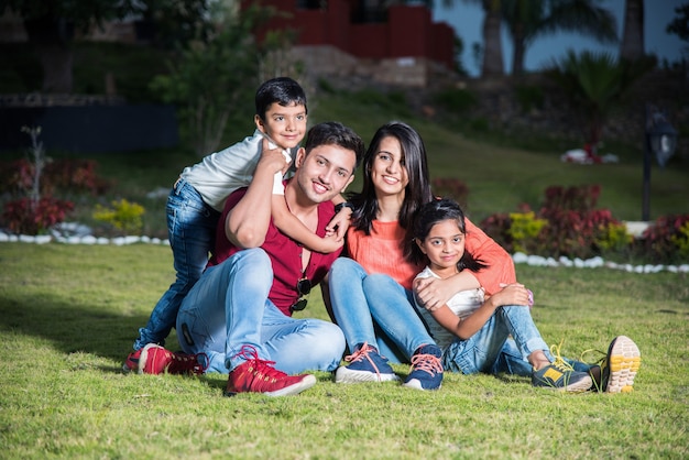 Retrato de família indiana asiática feliz sentado no gramado, ao ar livre