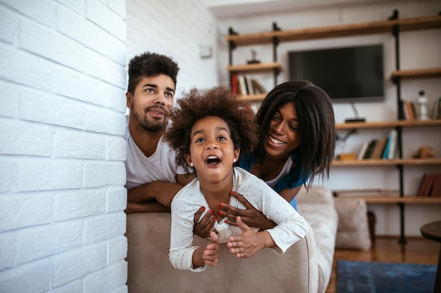 Retrato de família negra feliz se divertindo jogando em casa