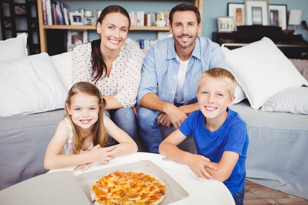 Retrato de família sorridente com pizza