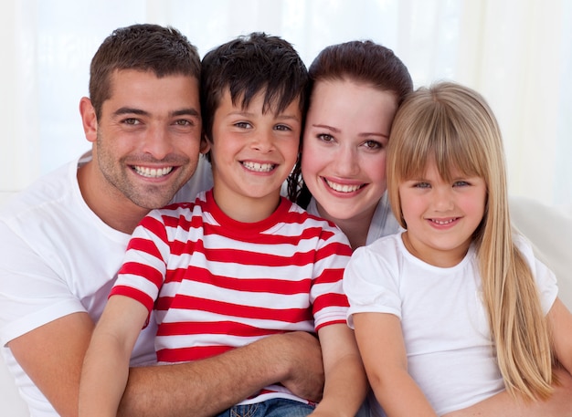 Retrato de família sorridente sentado no sofá juntos