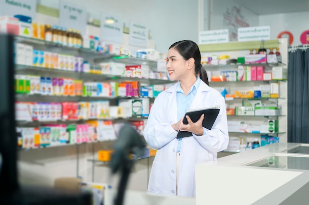 Retrato de farmacêutico feminino usando tablet em uma farmácia moderna