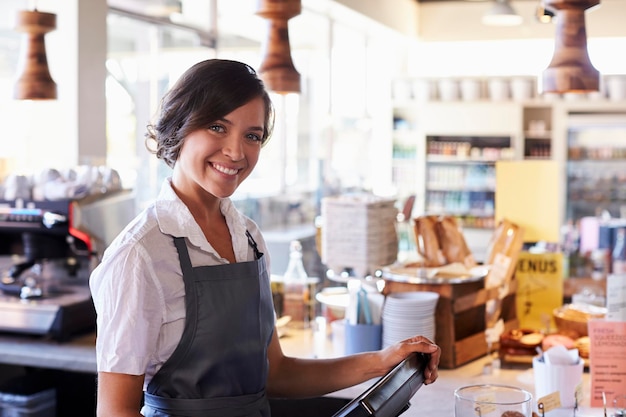 Retrato de funcionária trabalhando no caixa de Delicatessen