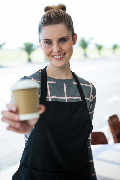 Foto retrato de garçonete sorridente oferecendo café