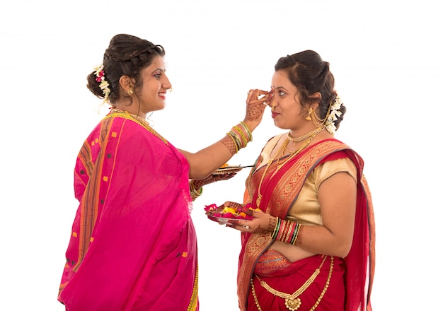 Retrato de garotas tradicionais indianas segurando diya e flower thali, irmãs celebrando diwali ou deepavali segurando uma lâmpada a óleo durante o festival no espaço em branco