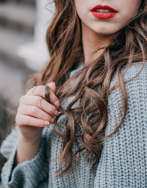 Retrato de glamour bela jovem com cabelo longo cacheado. Menina morena com cabelos cacheados compridos e brilhantes. Uma linda modelo de mulher com um penteado ondulado.