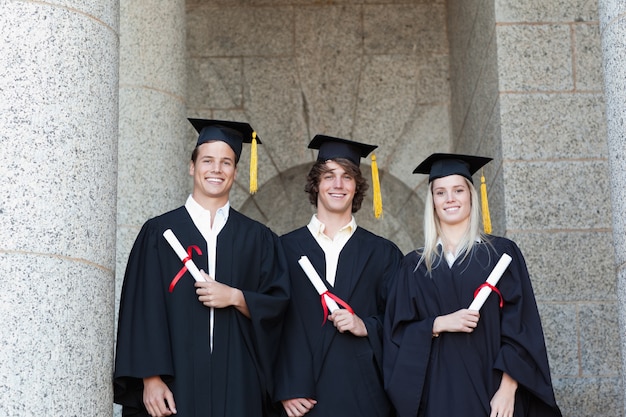 Retrato, de, graduados, segurando, seu, diploma, com, universidade, em, backgroung