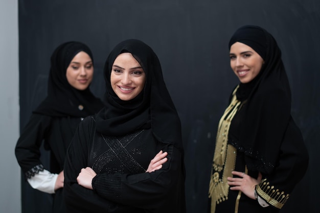 Retrato de grupo de belas mulheres muçulmanas em um vestido elegante com hijab isolado em fundo preto.