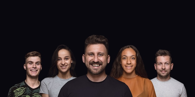 Foto retrato de grupo de pessoas emotivas na parede preta do estúdio