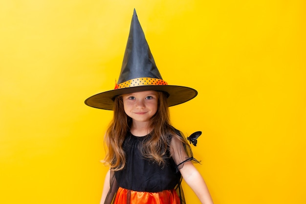 Retrato de Halloween de uma menina fantasiada de bruxa com uma borboleta negra viva no ombro