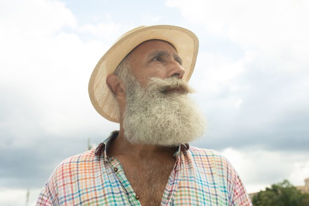 Foto retrato de homem adulto bonito elegante com barba em pé ao ar livre.