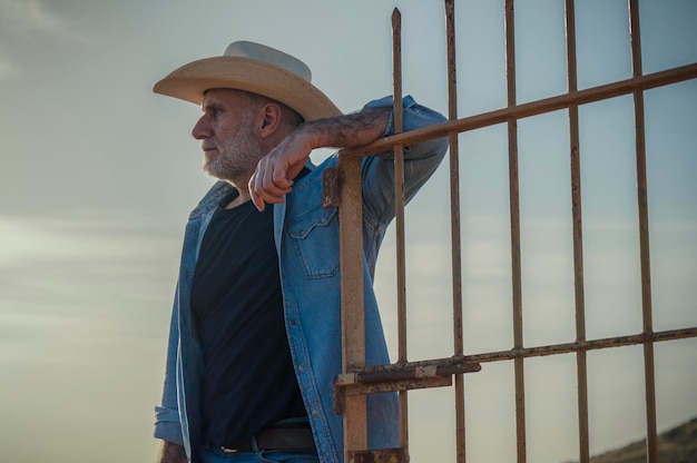 Retrato de homem adulto com chapéu de cowboy no campo