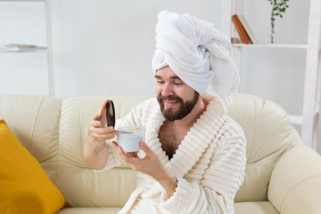 Retrato de homem aplicando creme eficaz em seu spa de pele facial em casa, corpo e cuidados com a pele para homens