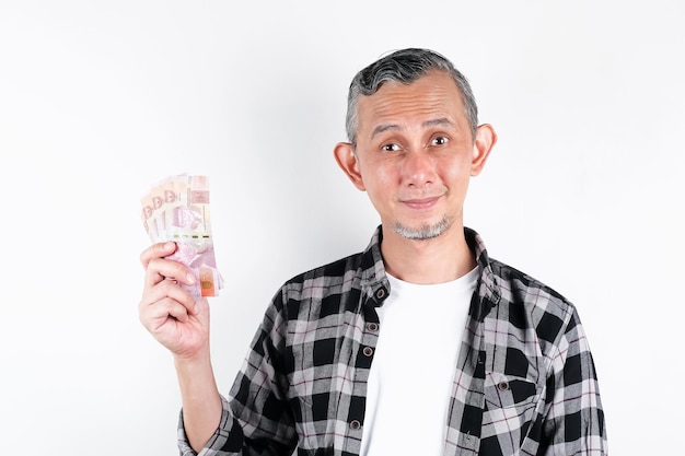 Retrato de homem asiático com camisa casual parecendo feliz por ter muito dinheiro na mão