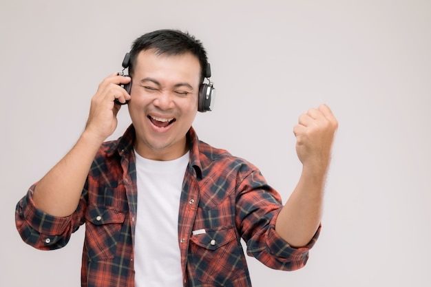 Retrato de homem asiático ouvindo música ou música de fone de ouvido preto.