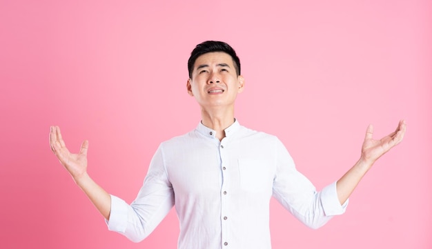 Retrato de homem asiático posando em fundo rosa