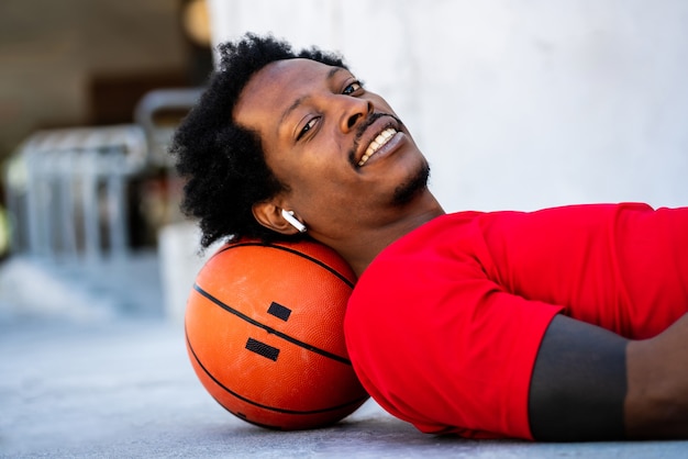 Retrato de homem atleta relaxando e deitado no chão após treinar ao ar livre