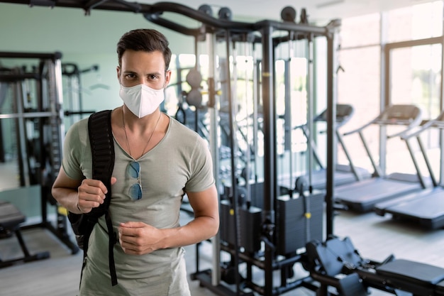 Retrato de homem atlético com máscara facial protetora em uma academia